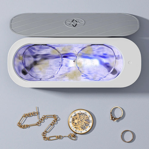 Nettoyeur à ultrasons compact avec lunettes et petits bijoux dans le bac de nettoyage